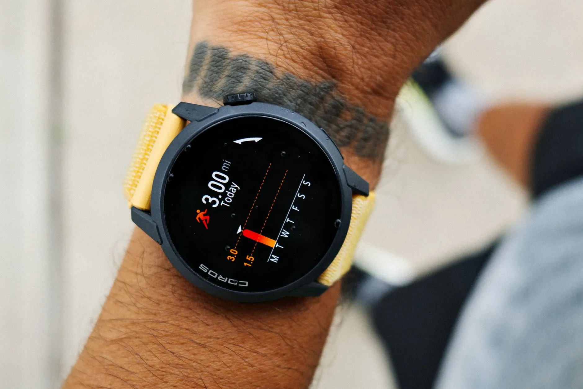 A close crop of a runner's wrist showing a smartwatch face with distance and pace from a three mile run.
